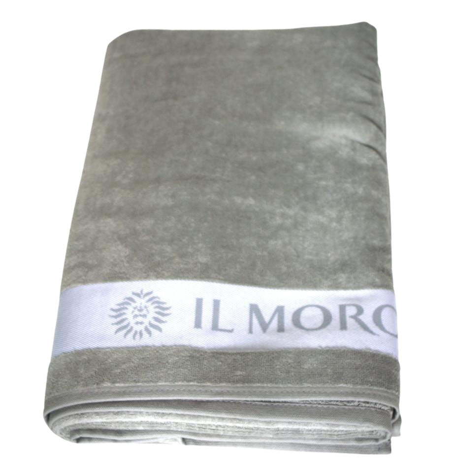 Il Telo ITA 143 grigio è realizzato interamente in cotone 100% e ha dimensioni di 100cm X 160cm. Una fascia bianca mette in risalto il logotipo “Il Moro di Venezia” Comodo e pratico, per la spiaggia, la piscina, l’attività fisica e il tempo libero. - The ITA 143 grey towel is made entirely of 100% cotton and measures 100cm X 160cm. A white band highlights the "Il Moro di Venezia" logo. Comfortable and practical, for the beach, the swimming pool, physical activity and leisure time.